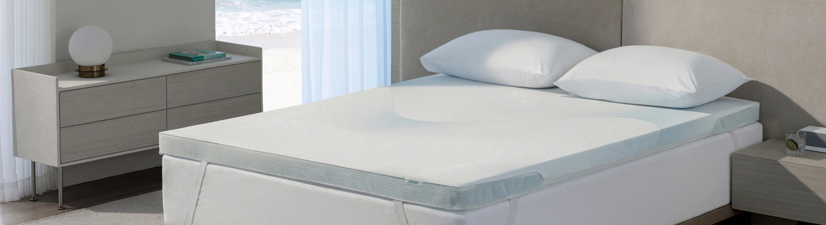 White mattress topper and pillows arranged on a bed