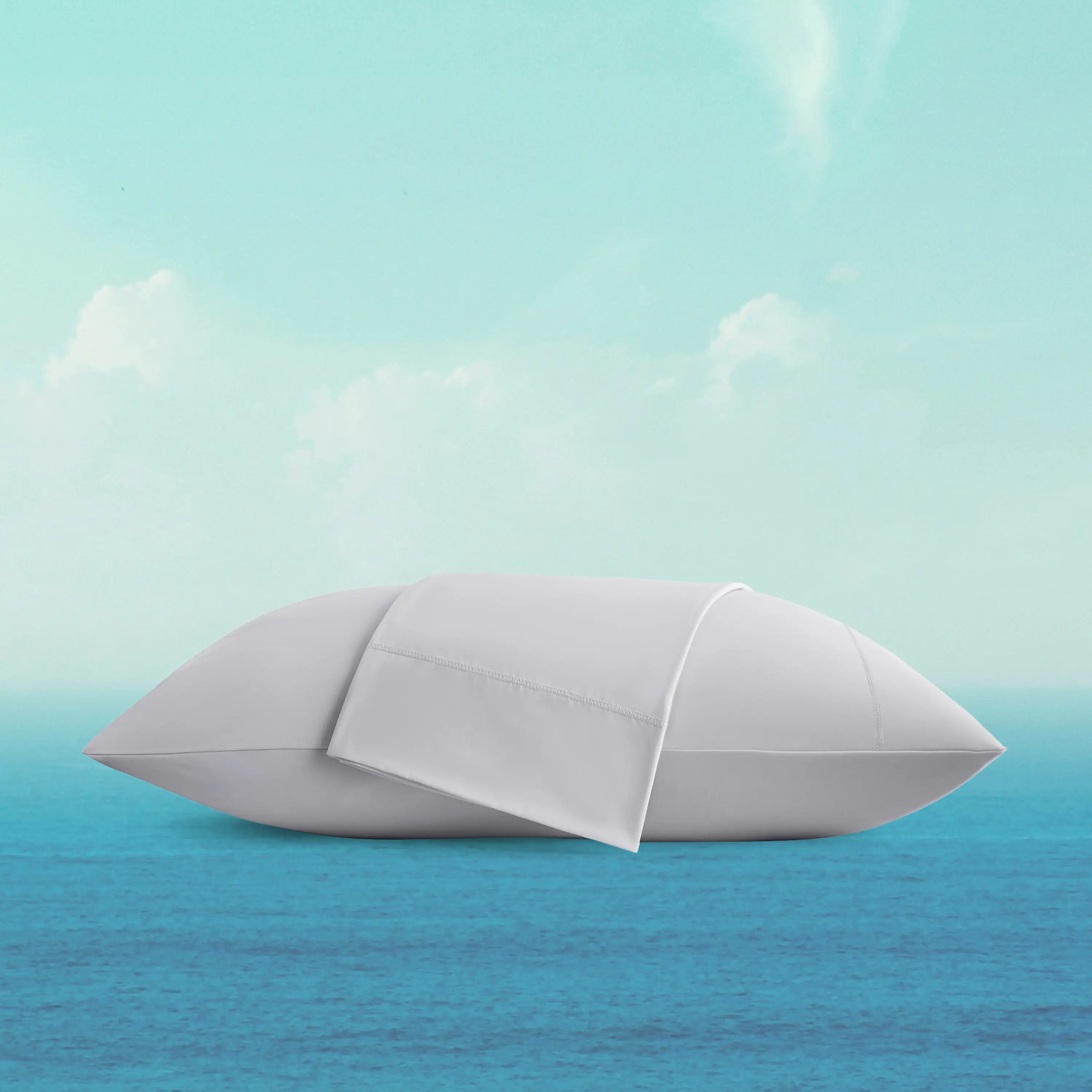White pillow floating on a blue surface with a light blue gradient background