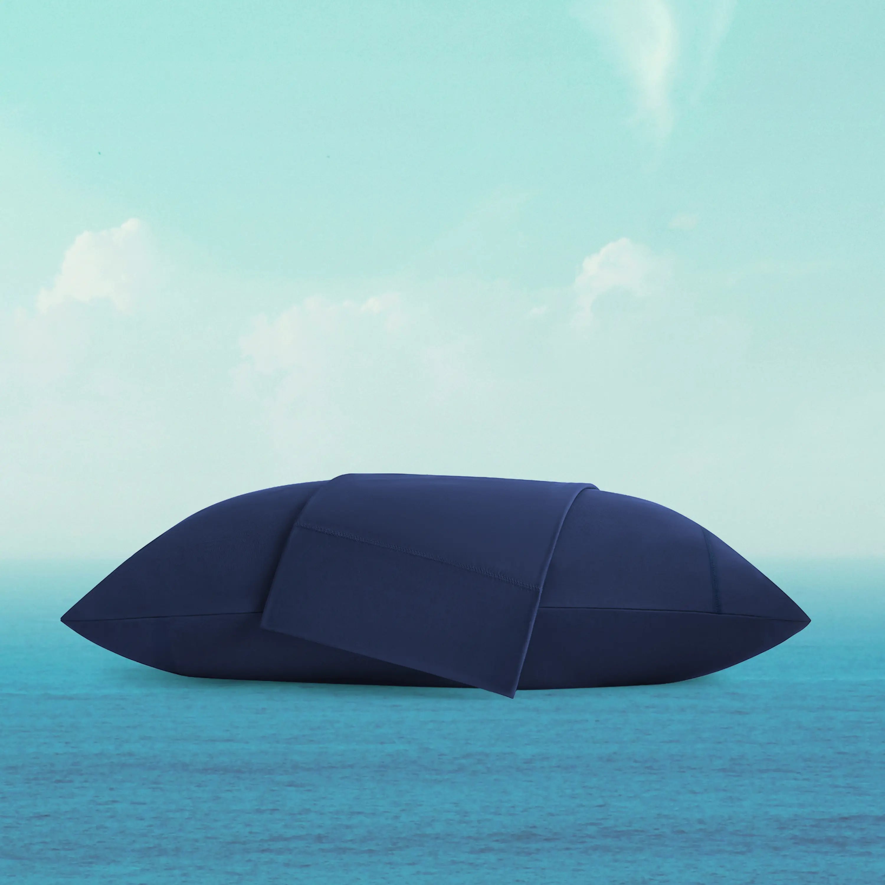 Blue umbrella floating on a blue ocean with a light blue sky.