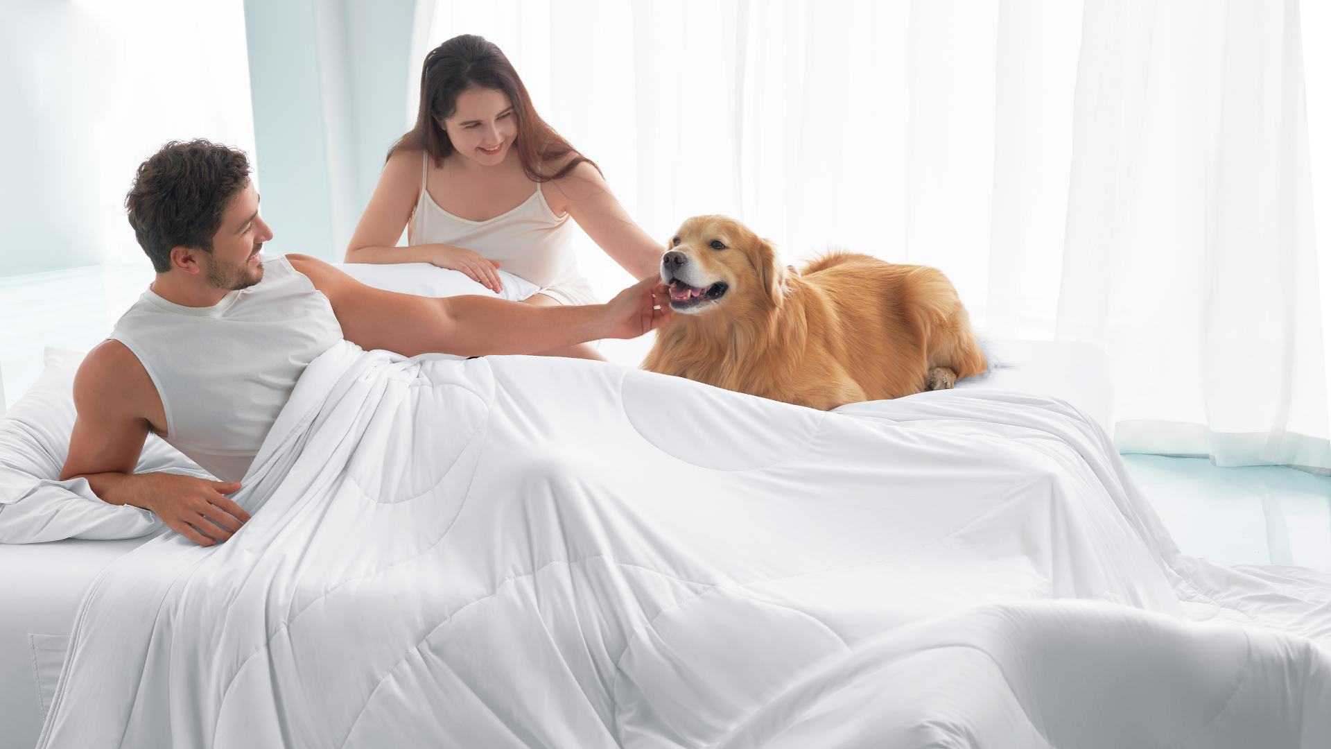 Happy couple with a golden retriever under a breathable cooling comforter, demonstrating the romantic benefit of better sleep and relationship intimacy.