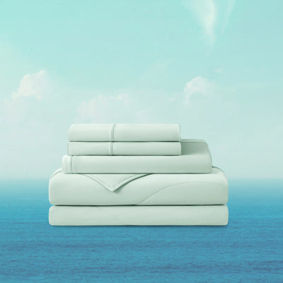Stack of light blue bedding sheets on a gradient background