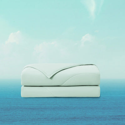 Folded light blue blanket on a gradient background