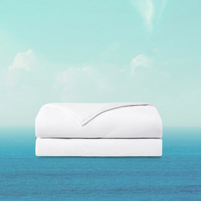 White quilt on a blue and green gradient background