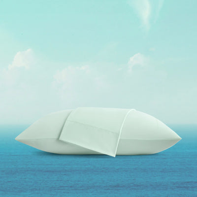 White paper boat on a blue water surface with a light blue sky.