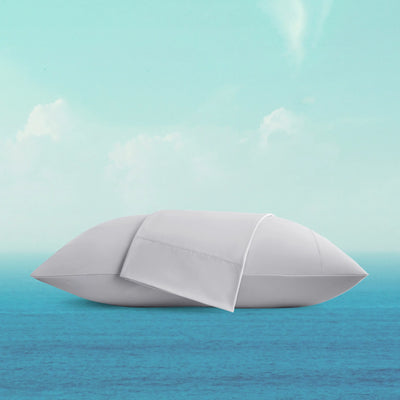 White pillow floating on a blue surface with a light blue gradient background