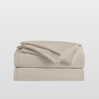 Beige bed sheets folded on a light gray background