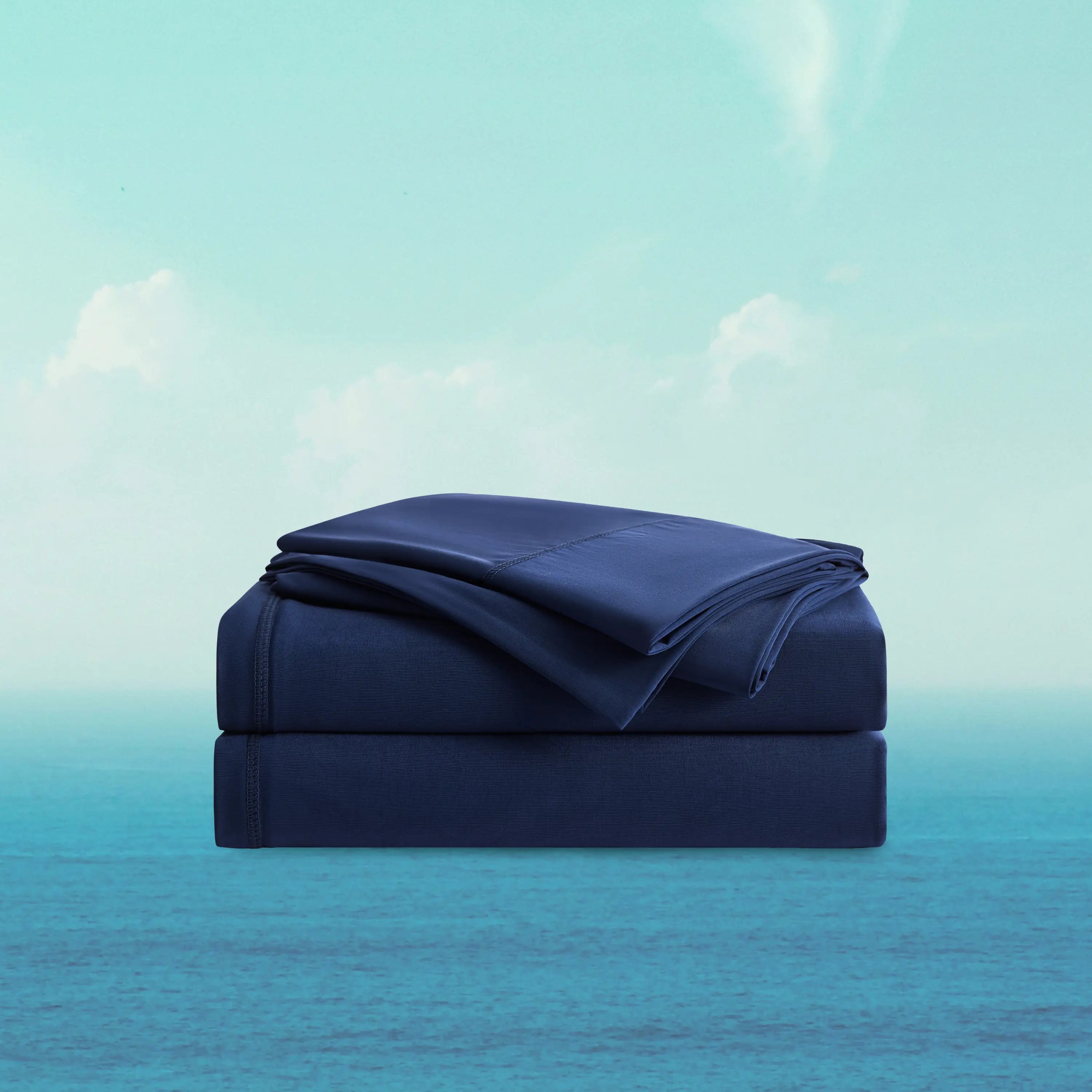Folded navy blue blanket on a matching mattress against a gradient background