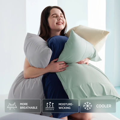 Woman holding two large pillows with product features displayed below. Ashley Graham Pick Breescape cooling bedding
