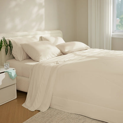 Neatly made bed with beige bedding in a bright bedroom. #color_ivory