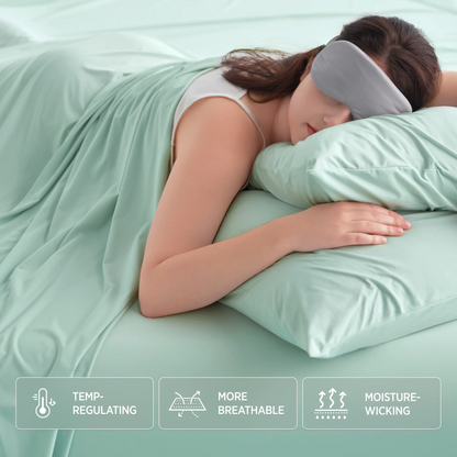 Woman sleeping with a green pillow and blanket, wearing a sleep mask, on a light green bed.  #color_mint-green