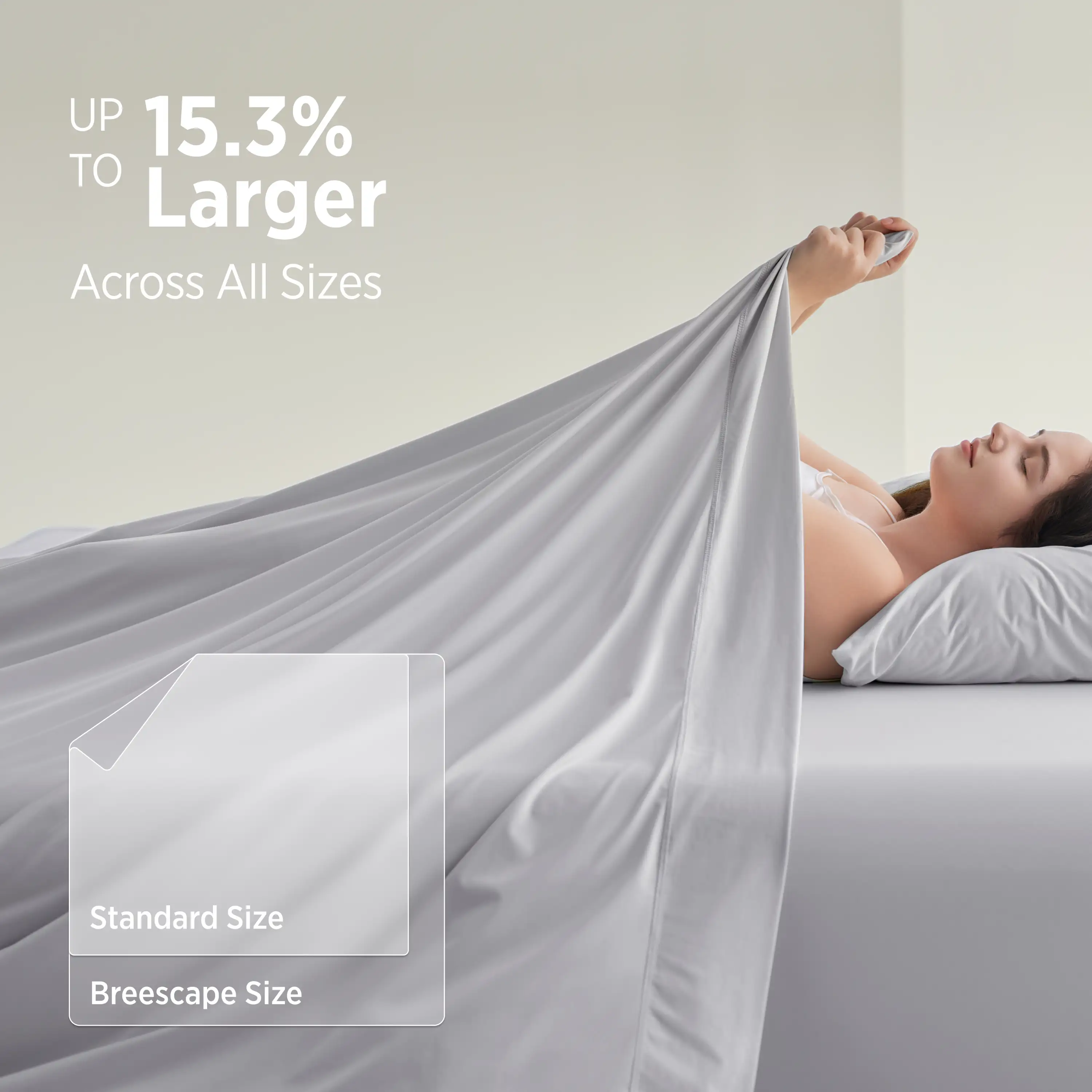 Woman lying in bed with a large gray blanket, showcasing size comparison text. #color_misty-grey