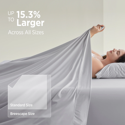 Woman lying in bed with a large gray blanket, showcasing size comparison text. #color_misty-grey