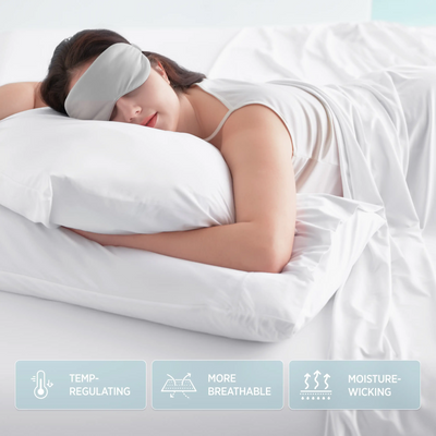 Woman sleeps with grey eye mask on white bedding. Features: Temp-Regulating, More Breathable, Moisture-Wicking.