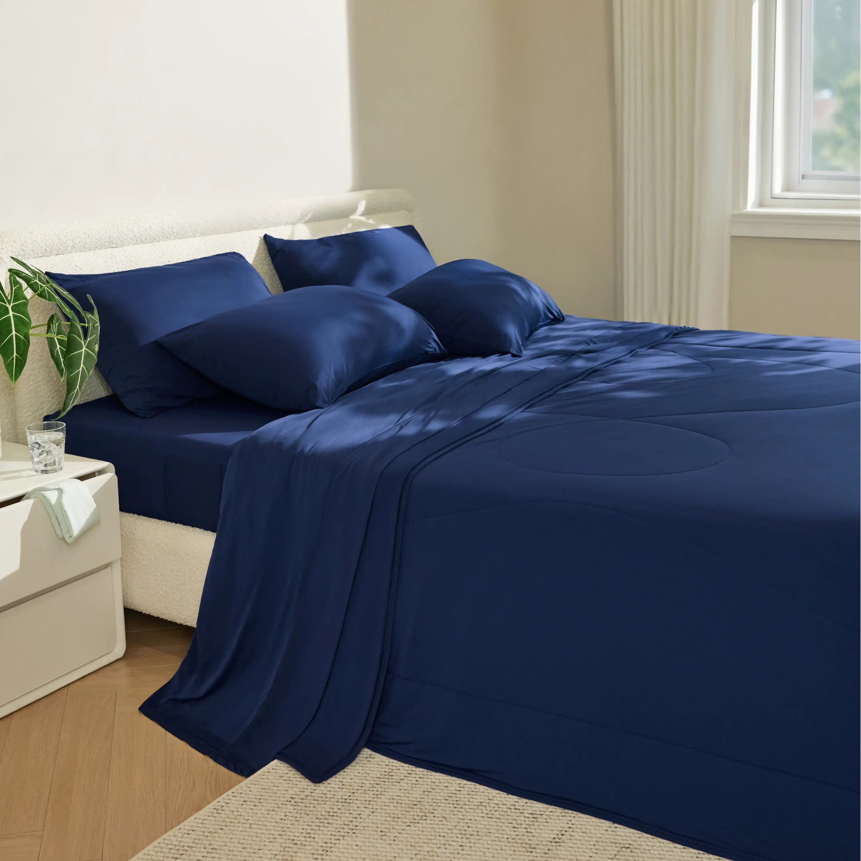 Navy blue satin sheet set on a bed in a bedroom. #color_twilight-blue